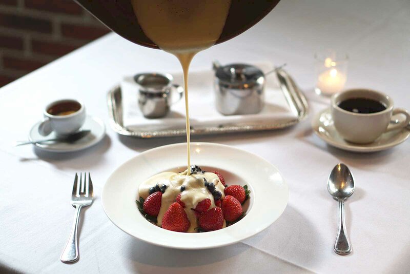 Cream being poured onto fresh cut fruit with coffee drinks