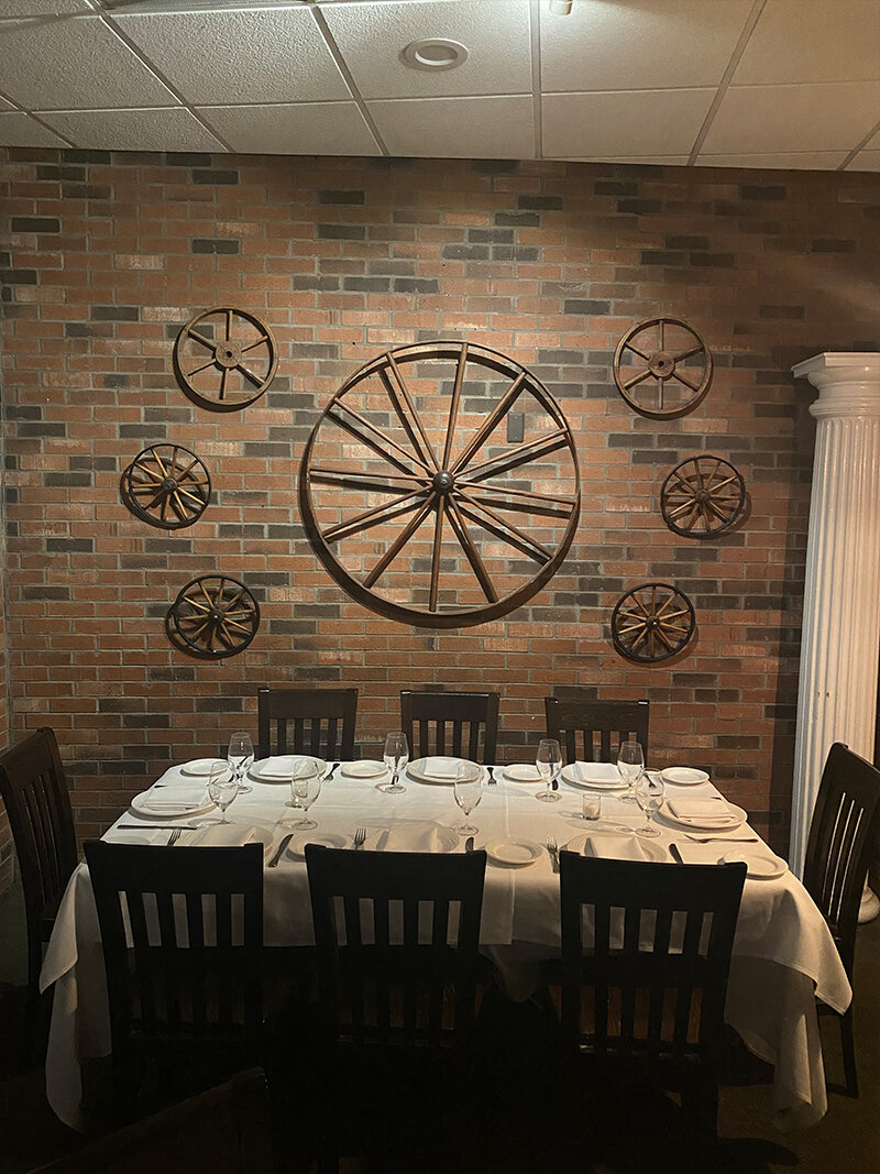 Iron wheels on wall above table set for 8 guests