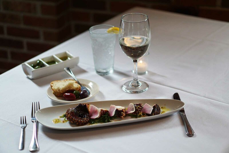 Octopus appetizer with glass of wine