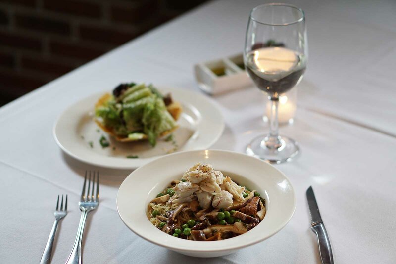 Seafood entree with side salad and glass of wine