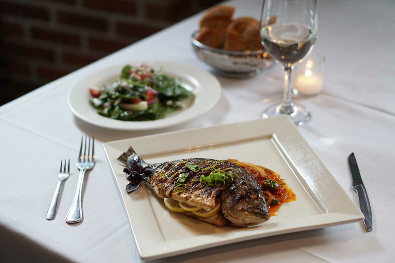 Fish entree with side salad and glass of wine